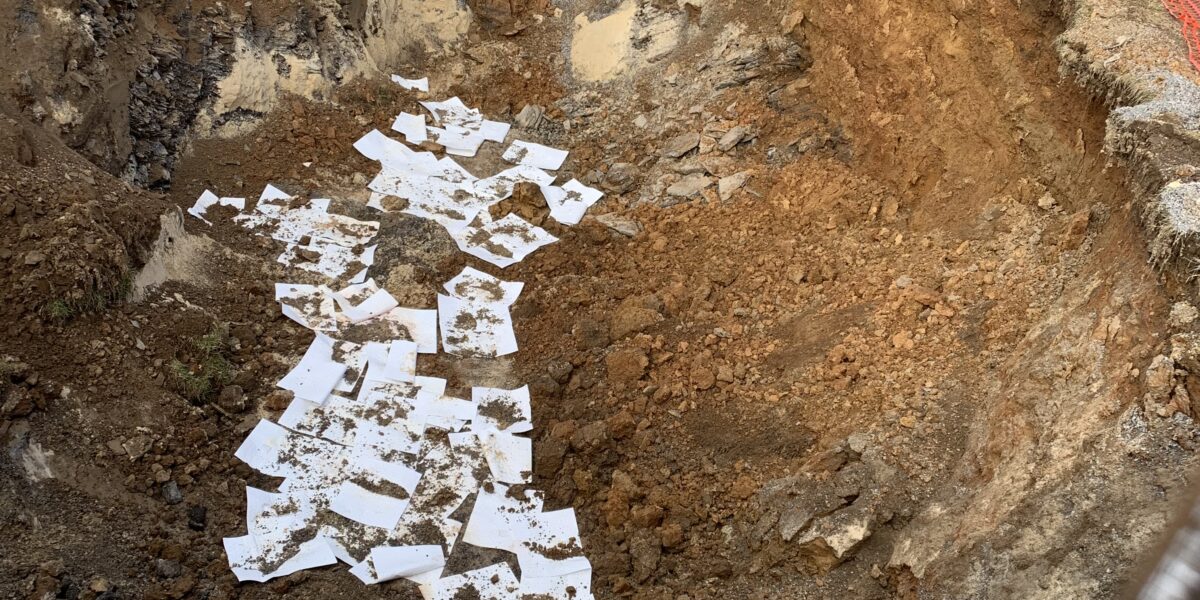 A pile of paper sitting in the dirt.